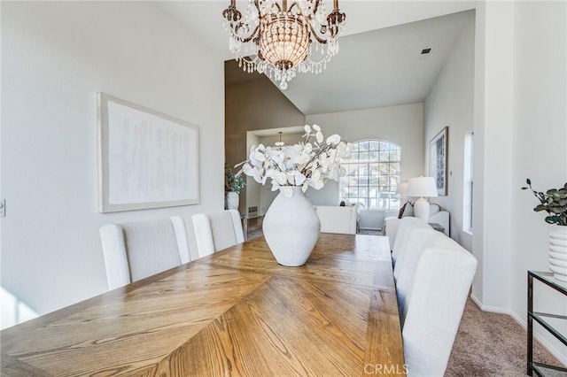 dining room with carpet floors, visible vents, an inviting chandelier, vaulted ceiling, and baseboards