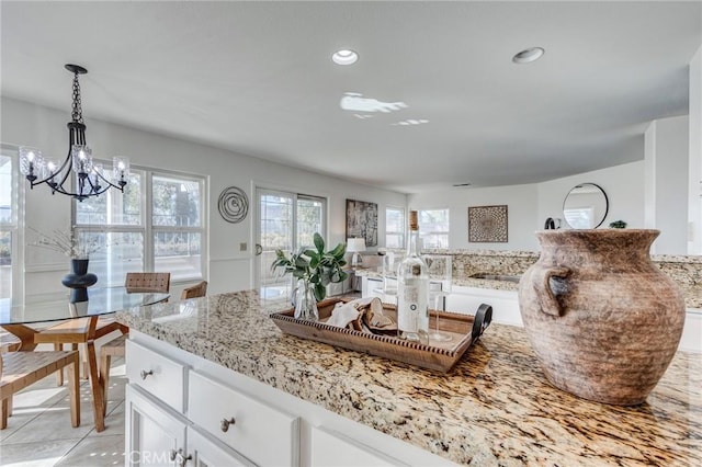 kitchen featuring light stone counters, hanging light fixtures, light tile patterned flooring, white cabinetry, and recessed lighting