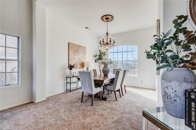 carpeted dining room with baseboards, a healthy amount of sunlight, visible vents, and a notable chandelier