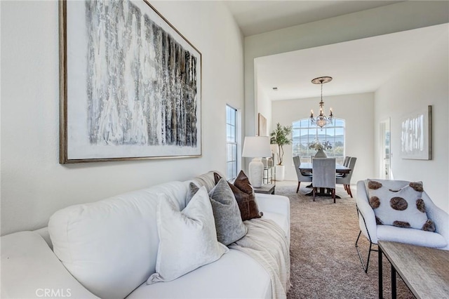 carpeted living room featuring a chandelier