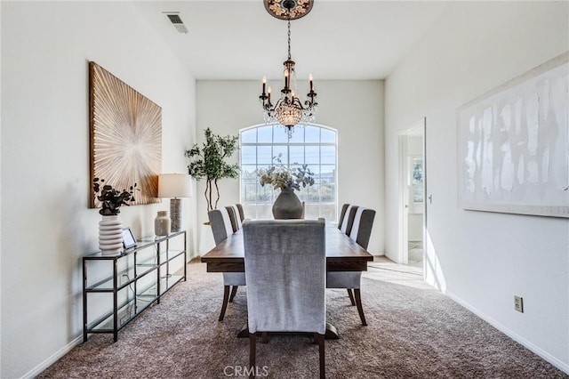 carpeted dining room featuring vaulted ceiling, visible vents, a notable chandelier, and baseboards