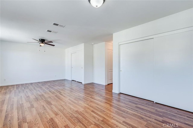 unfurnished room featuring a ceiling fan, light wood-type flooring, visible vents, and baseboards