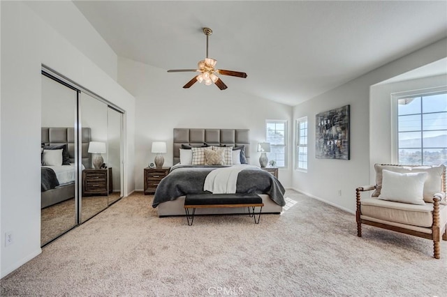 bedroom featuring baseboards, a ceiling fan, light colored carpet, lofted ceiling, and a closet