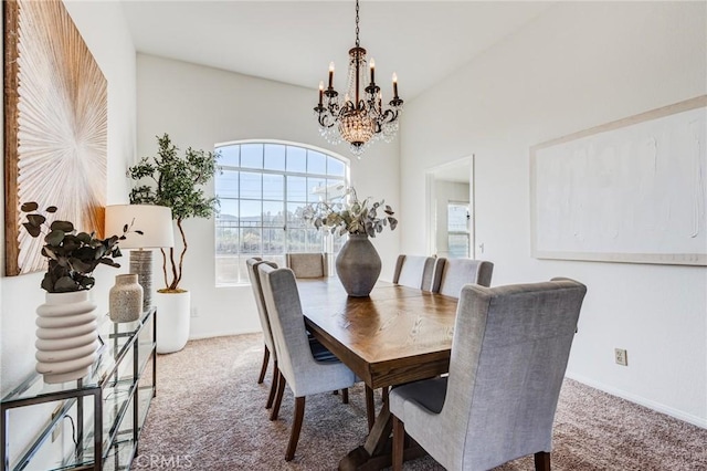 carpeted dining area with baseboards and a chandelier