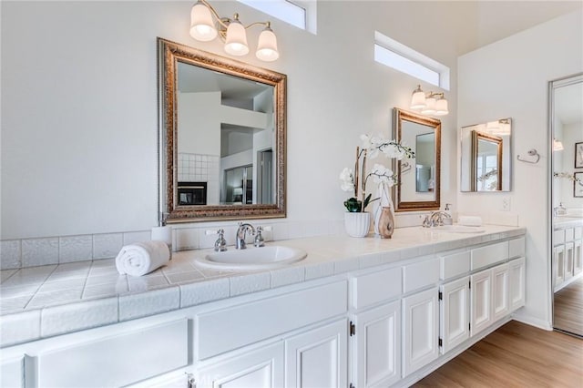 bathroom with double vanity, a sink, and wood finished floors