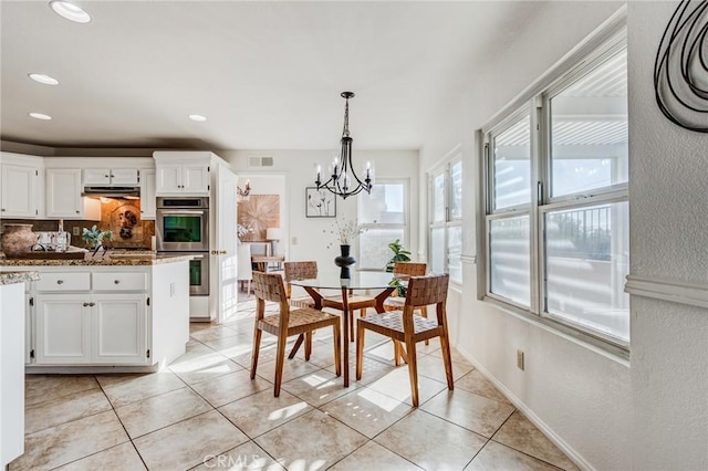 dining space featuring a chandelier, recessed lighting, baseboards, and light tile patterned floors