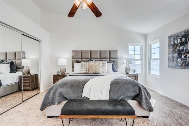 bedroom with ceiling fan, baseboards, vaulted ceiling, a closet, and carpet