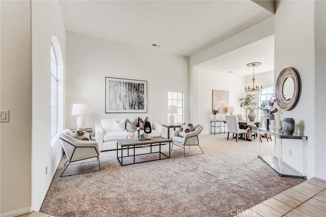 carpeted living area featuring visible vents and a notable chandelier