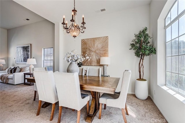 carpeted dining room featuring baseboards, an inviting chandelier, visible vents, and a healthy amount of sunlight