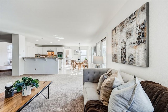 living area featuring an inviting chandelier, recessed lighting, and light colored carpet