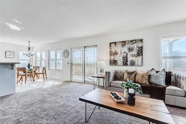 carpeted living area with a chandelier and a wealth of natural light