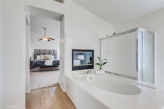 full bathroom with a garden tub, wood finished floors, a ceiling fan, a shower stall, and ensuite bath