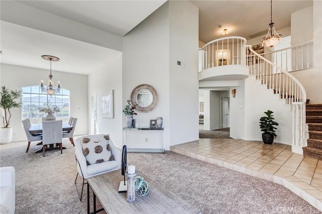 carpeted living area with tile patterned flooring, visible vents, a towering ceiling, stairway, and an inviting chandelier