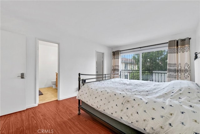 bedroom featuring access to exterior, ensuite bathroom, and hardwood / wood-style floors