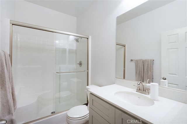 bathroom featuring vanity, toilet, and a shower with door