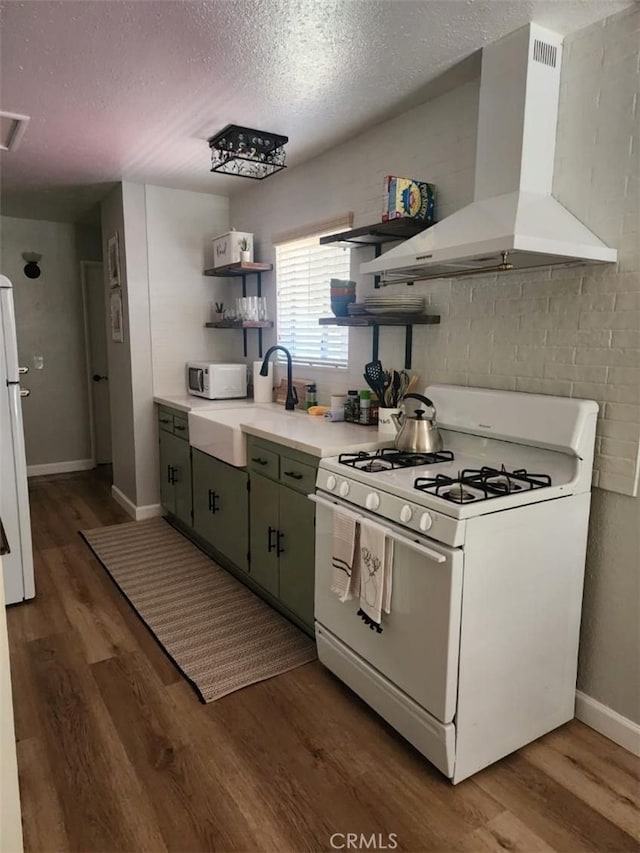 kitchen featuring white appliances, dark wood-type flooring, sink, wall chimney exhaust hood, and a textured ceiling