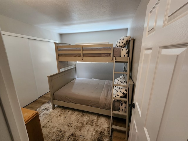 bedroom with a textured ceiling and hardwood / wood-style flooring