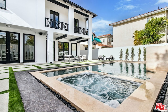 view of pool with a patio area, an in ground hot tub, and french doors