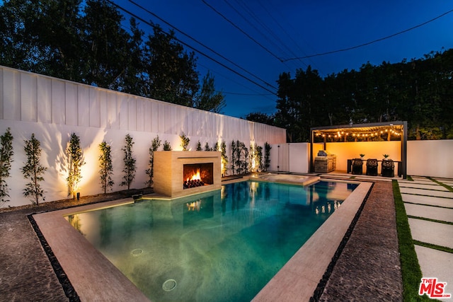 view of pool with a patio and an outdoor fireplace