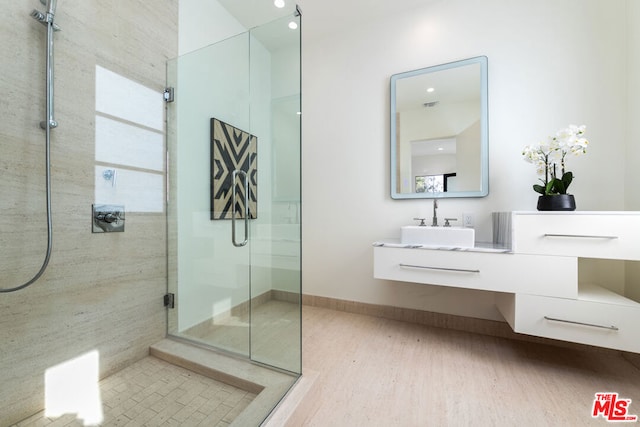 bathroom with vanity, an enclosed shower, and hardwood / wood-style flooring