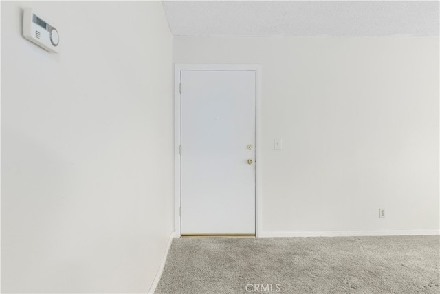 spare room featuring carpet floors and a textured ceiling