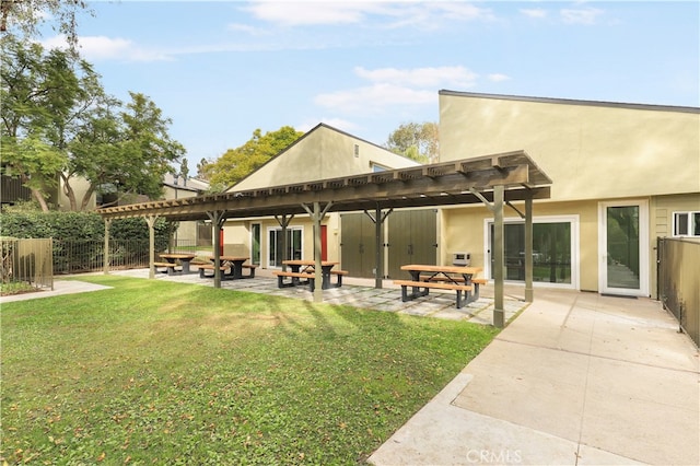 rear view of property with a yard, a pergola, and a patio area