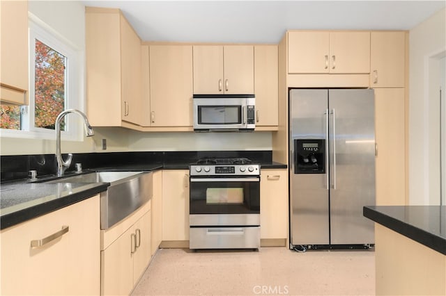 kitchen with cream cabinets, stainless steel appliances, and sink