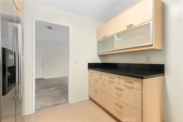 kitchen with stainless steel fridge and light colored carpet