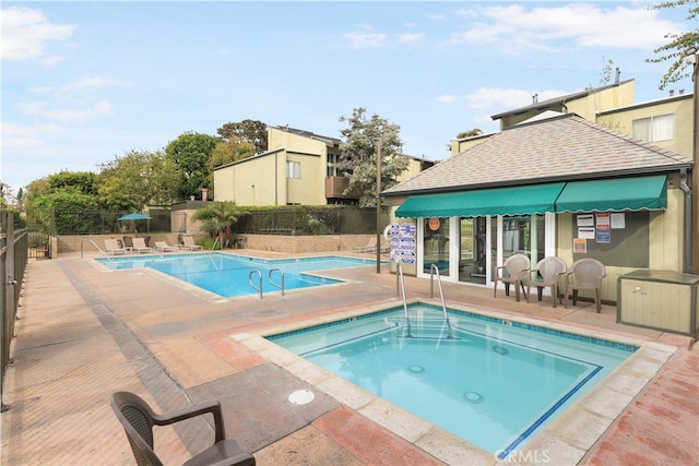 view of swimming pool with a patio area and a community hot tub