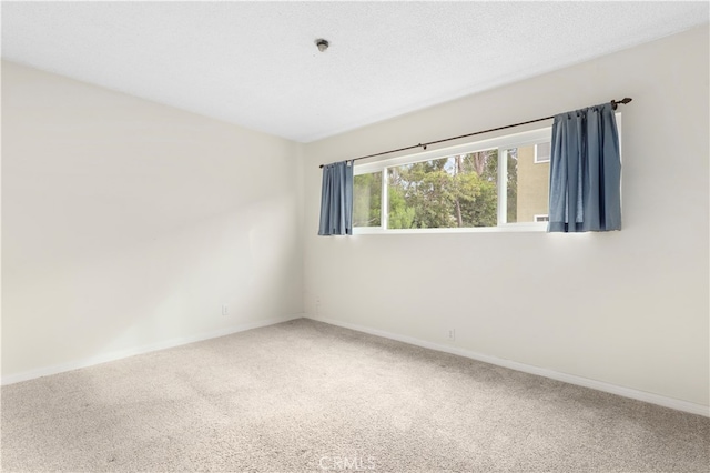 spare room featuring carpet and a textured ceiling