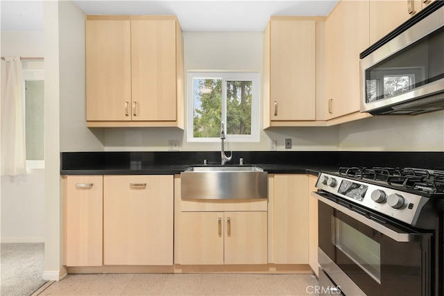 kitchen with light brown cabinets, stainless steel appliances, and sink