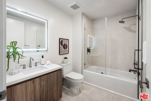 full bathroom featuring vanity, tile patterned floors, tiled shower / bath combo, and toilet