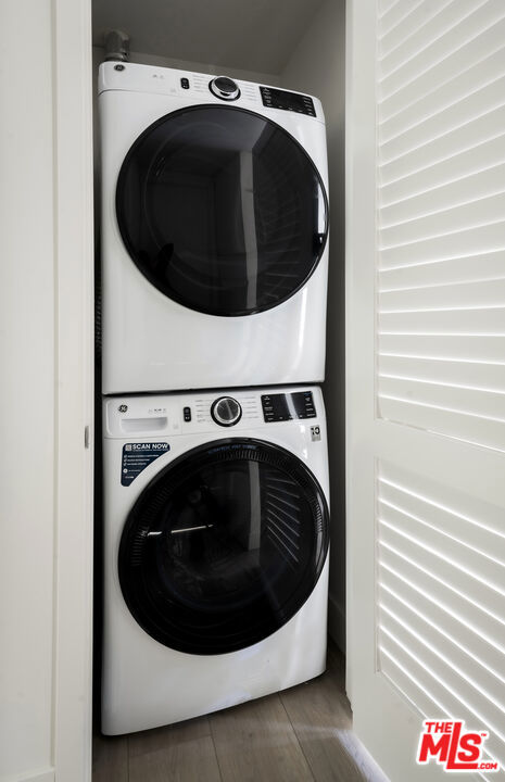 clothes washing area with stacked washer and clothes dryer