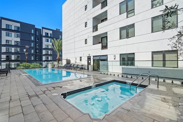 view of swimming pool with a community hot tub and a patio