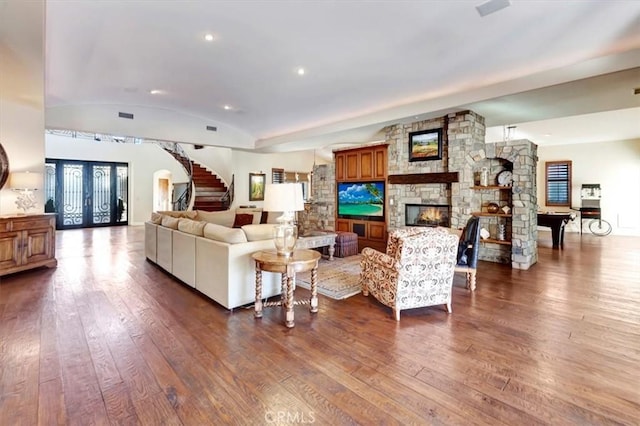 living room featuring a fireplace, french doors, dark hardwood / wood-style floors, and vaulted ceiling