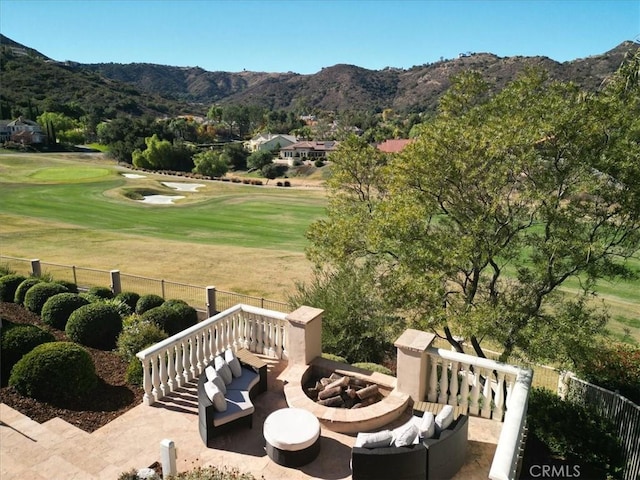 view of property's community with a lawn, a mountain view, and an outdoor living space with a fire pit