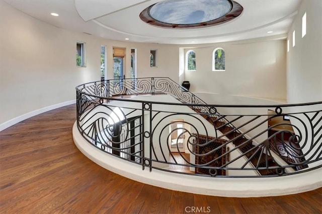 stairway featuring wood-type flooring and a tray ceiling