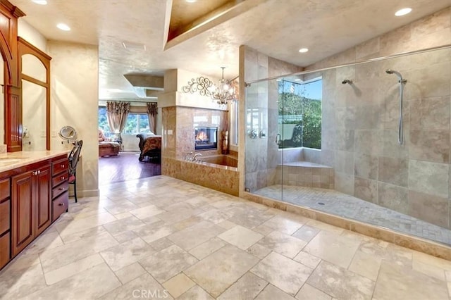 bathroom with separate shower and tub, vanity, and a chandelier