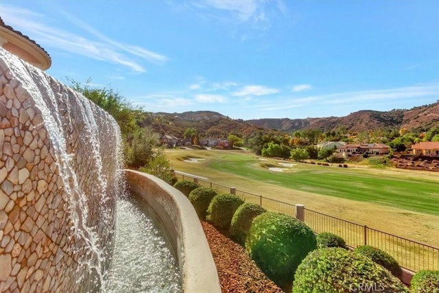 view of property's community featuring a lawn and a mountain view