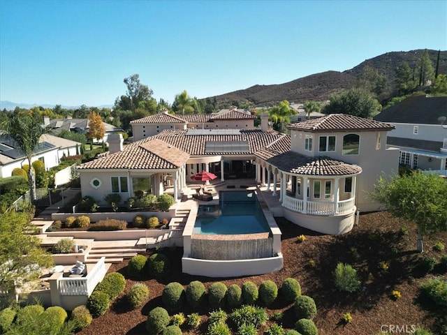 back of house featuring a mountain view and a patio area