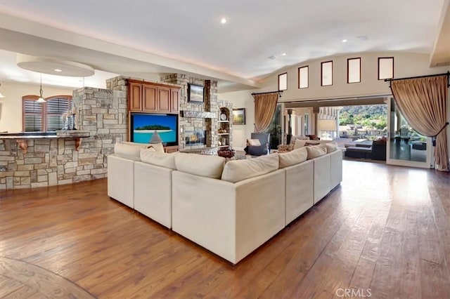 living room featuring a fireplace, light wood-type flooring, and lofted ceiling