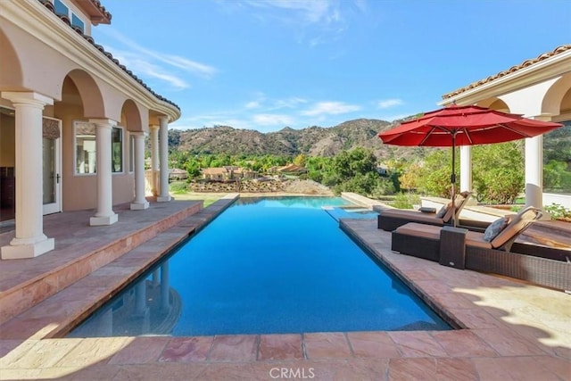 view of pool featuring a mountain view and a patio