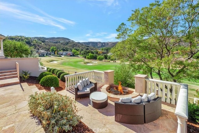 view of patio / terrace with a mountain view and an outdoor living space with a fire pit