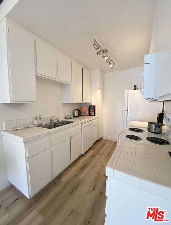 kitchen featuring white cabinetry, sink, white appliances, and light hardwood / wood-style flooring