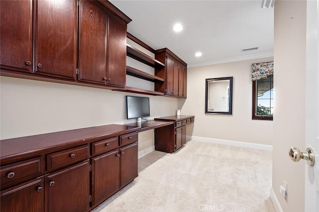 office featuring light colored carpet, built in desk, and crown molding