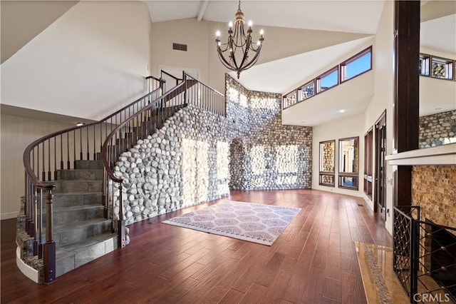 entrance foyer with beamed ceiling, dark hardwood / wood-style flooring, high vaulted ceiling, and a chandelier