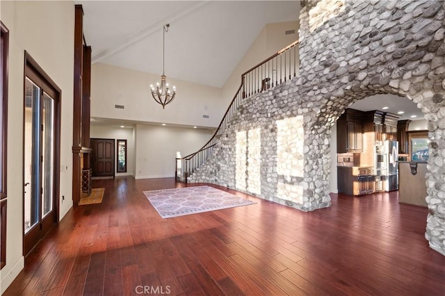 foyer featuring dark hardwood / wood-style flooring, high vaulted ceiling, and an inviting chandelier