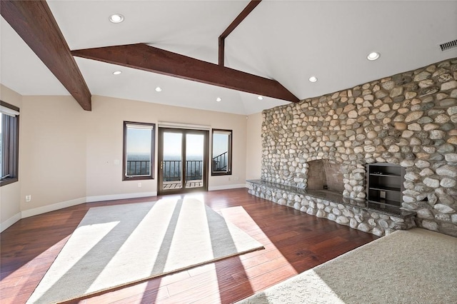 unfurnished living room featuring lofted ceiling with beams, dark hardwood / wood-style floors, and a fireplace