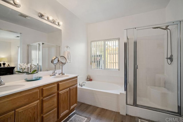 bathroom with hardwood / wood-style floors, vanity, and separate shower and tub