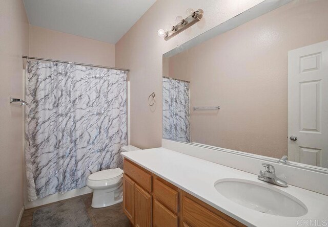 bathroom featuring tile patterned flooring, vanity, toilet, and a shower with curtain